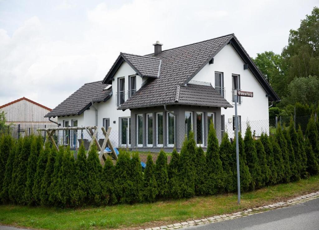 uma casa branca com um telhado preto em Ferienhaus Pusteblume em Freyung
