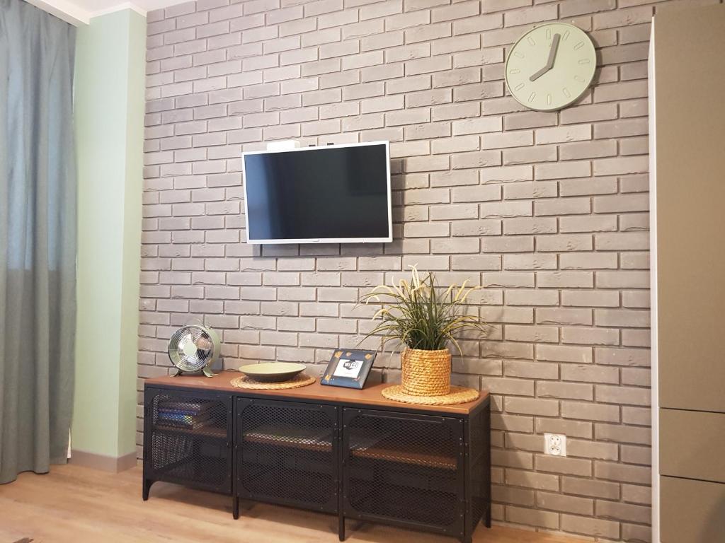 a wall with a tv on a brick wall at Apartament ul Okopowa - Parking płatny in Kołobrzeg