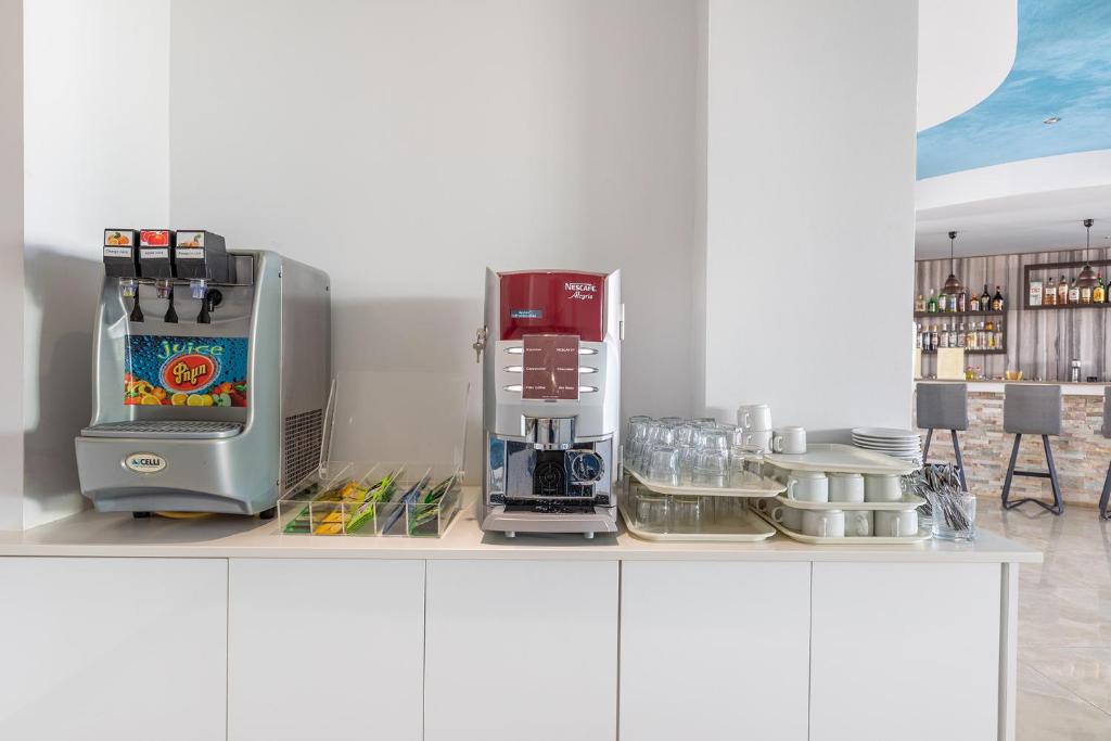 a kitchen counter with a coffee maker and a mixer at Bellini Hotel in Ayia Napa