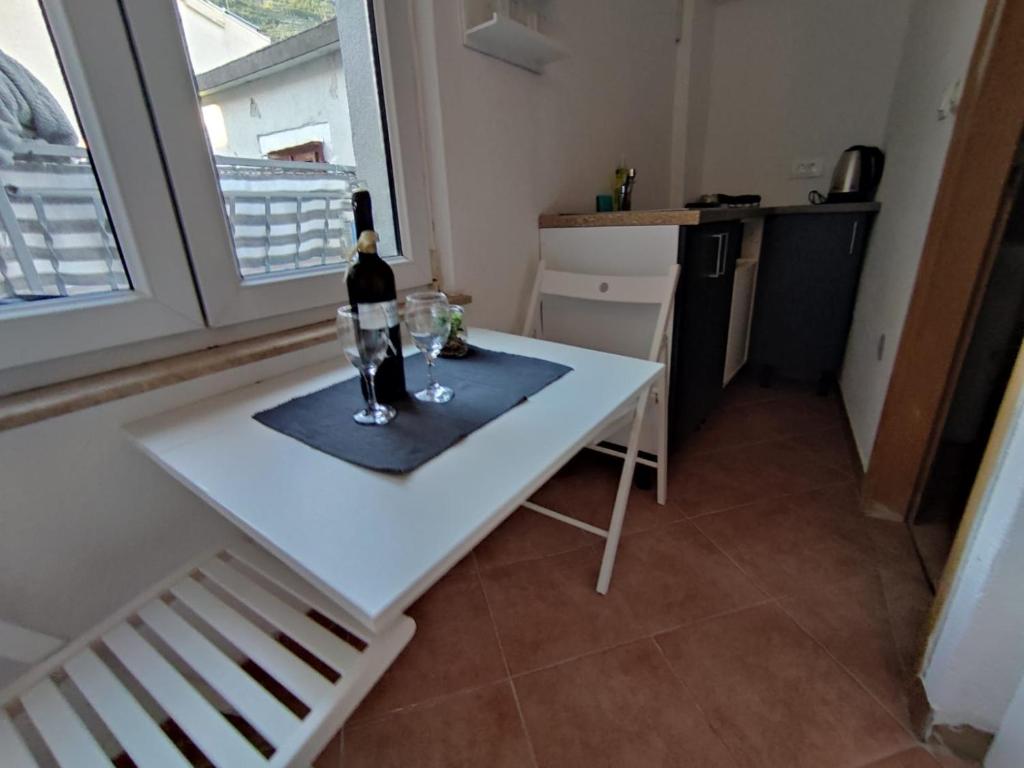 - une bouteille de vin sur une table blanche dans la cuisine dans l'établissement Private bedroom with bathroom, à Baška Voda