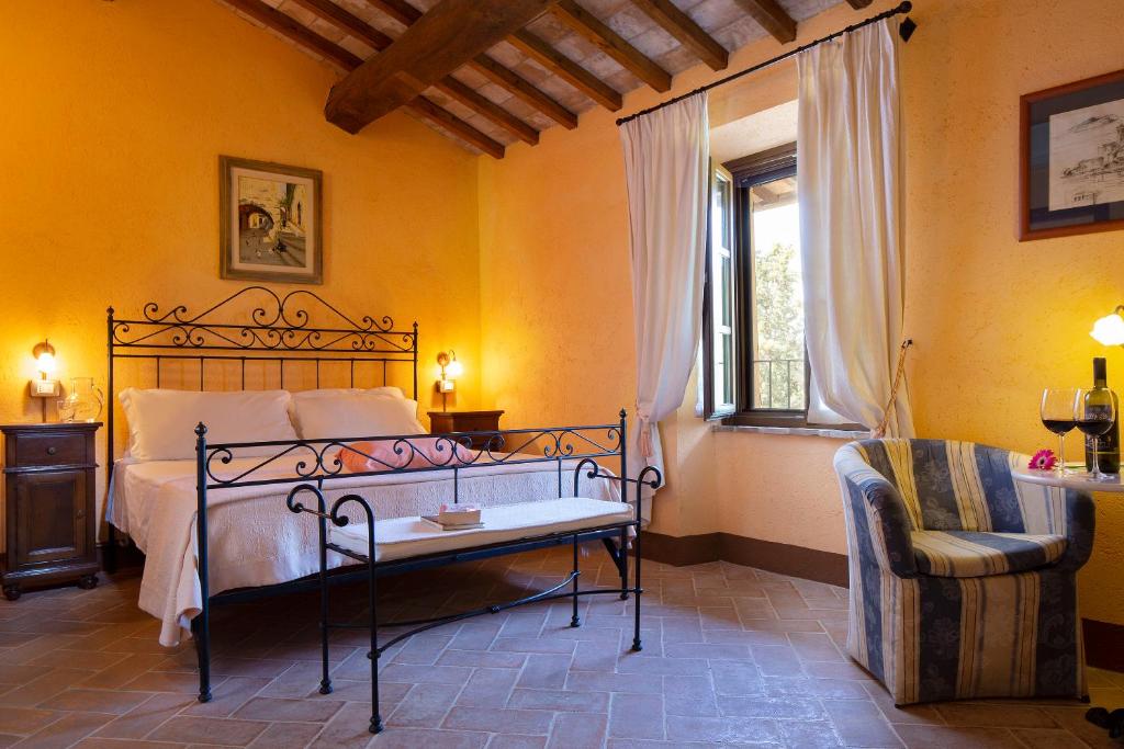 a bedroom with a bed and a chair and a window at Agriturismo Colle Pu in Assisi