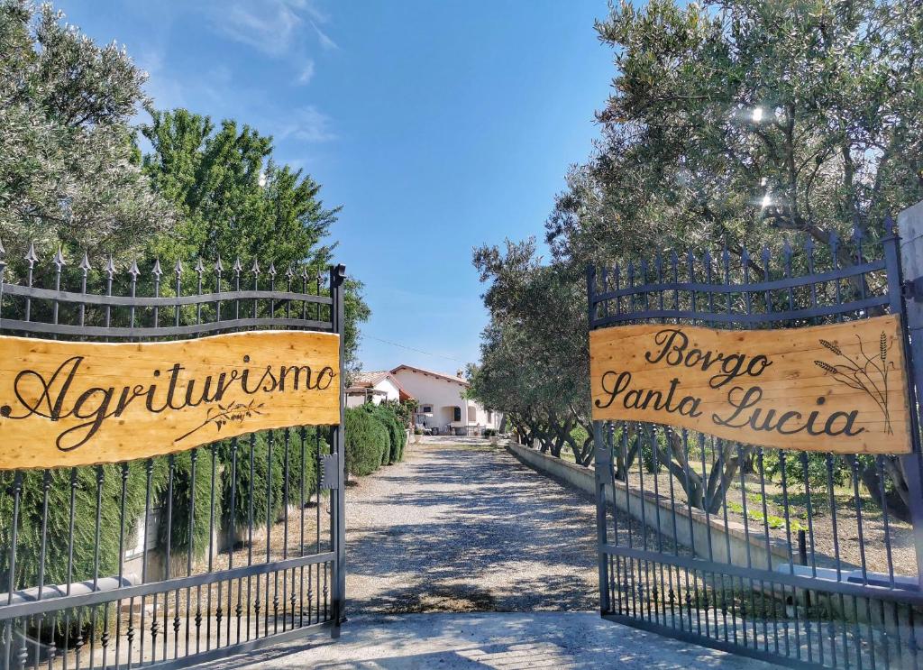 a gate to a driveway with signs on it at Borgo Santa Lucia in Cropani