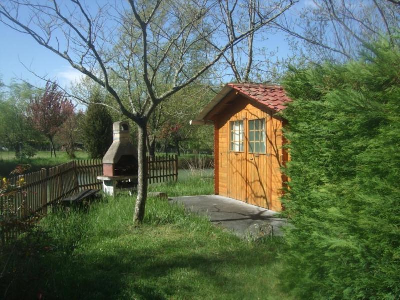 een kleine hut met een houtkachel in een tuin bij Gîte 6 personnes Les Gîtes du Chardon in Teuillac