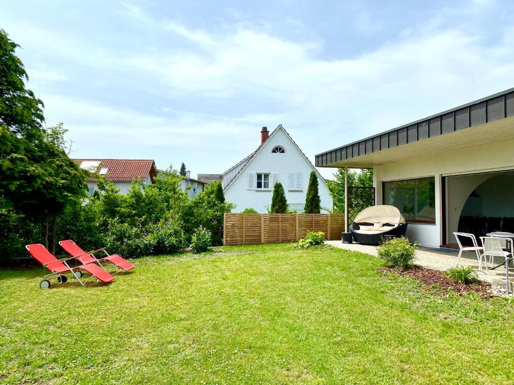 een tuin met een groep stoelen en een huis bij Bodensee Bungalow in Immenstaad am Bodensee