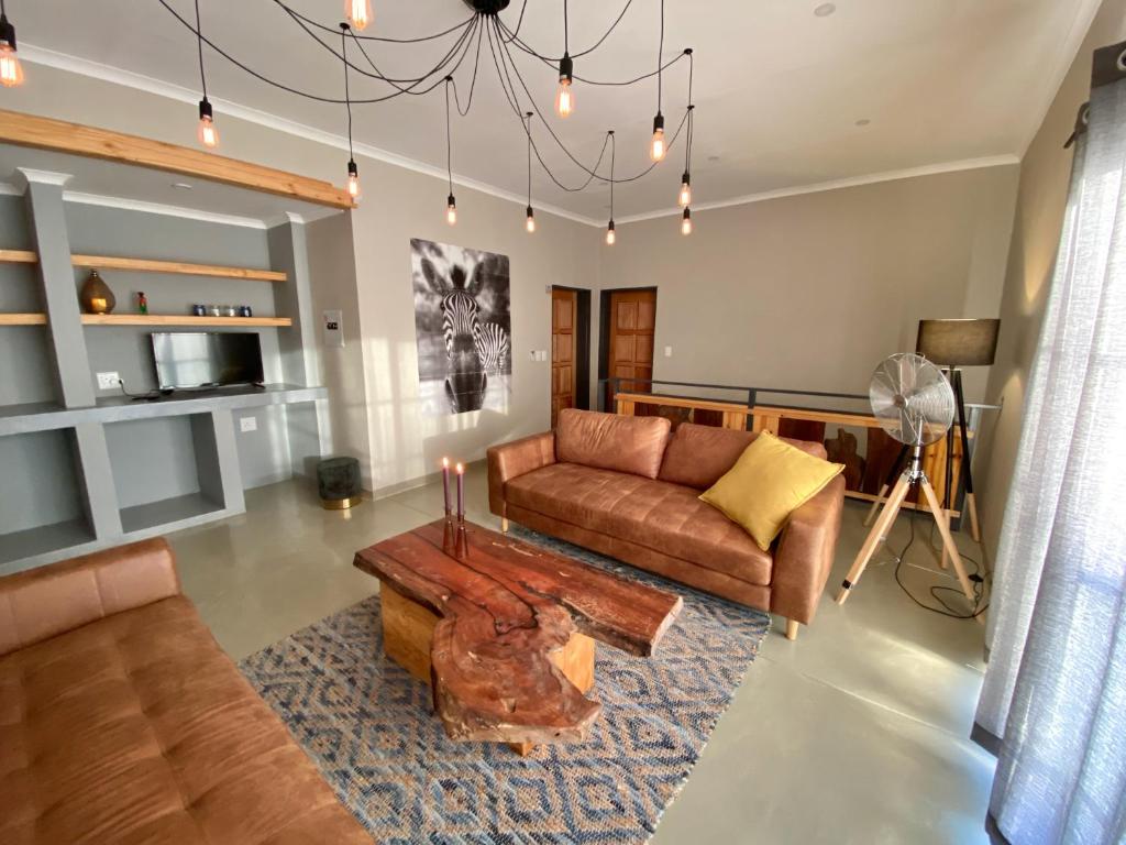 uma sala de estar com um sofá e uma mesa em Jackals Dream - Self Catering Villa bordering Kruger National Park em Marloth Park