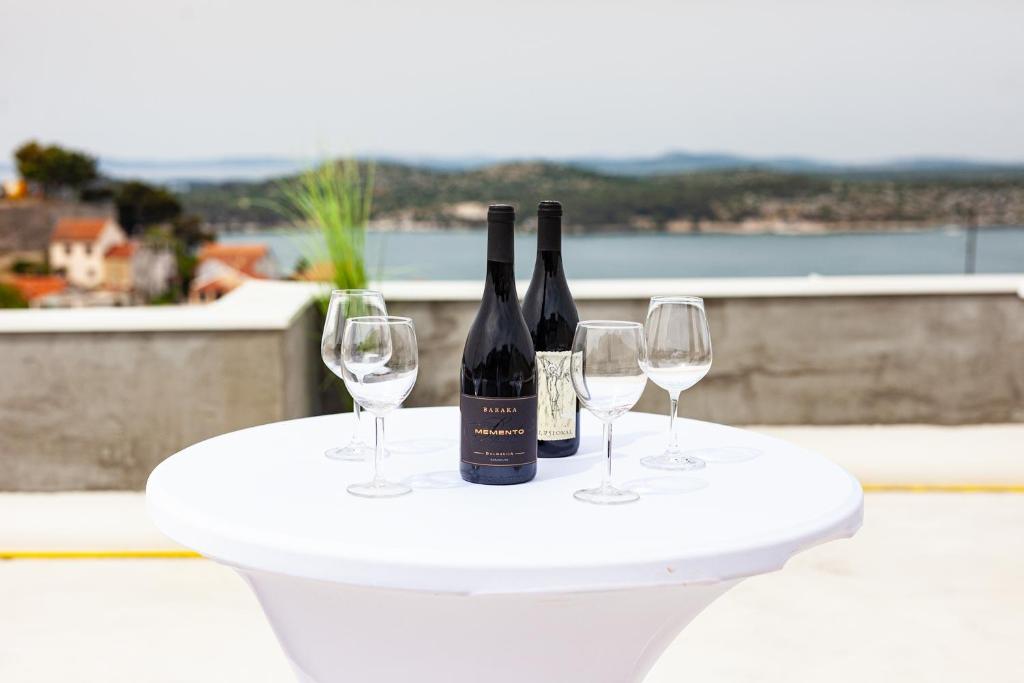 two bottles and two glasses of wine on a table at Andriana House in Šibenik