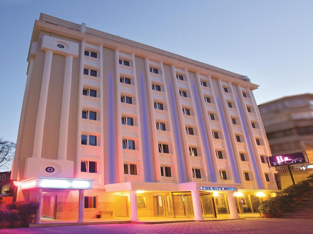 ein großes Gebäude mit beleuchteter Fassade in der Nacht in der Unterkunft The City Hotel in Istanbul