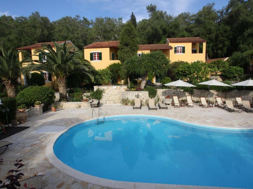 a large swimming pool in front of a house at Andrikos Studios in Lákka