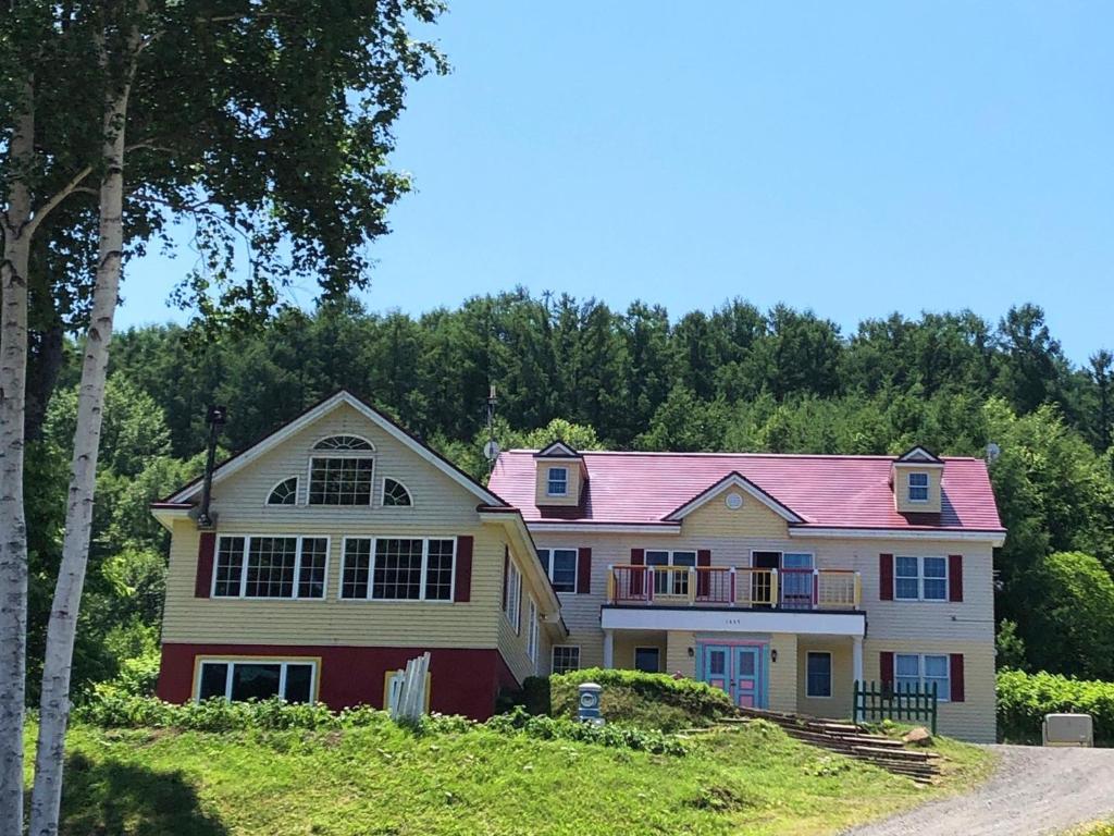 una casa con techo rosa en una colina en Furano - Hotel / Vacation STAY 35781, en Furano