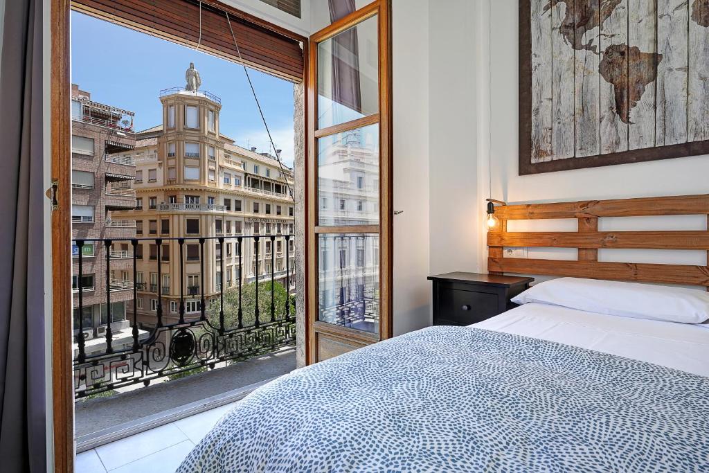 1 dormitorio con cama y ventana grande en Pepa Home, en Granada