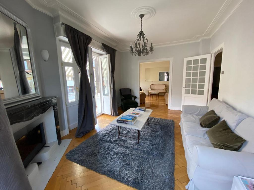 a living room with a white couch and a table at Elegant Duplex de Haut Standing de 230m2 in La Roche-sur-Foron
