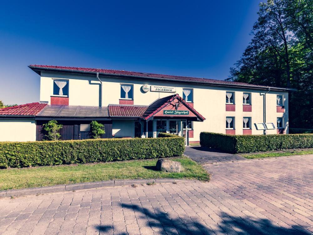 a large white building with a red roof at Hotel und Appartements Jägerhof Rügen in Lancken-Granitz