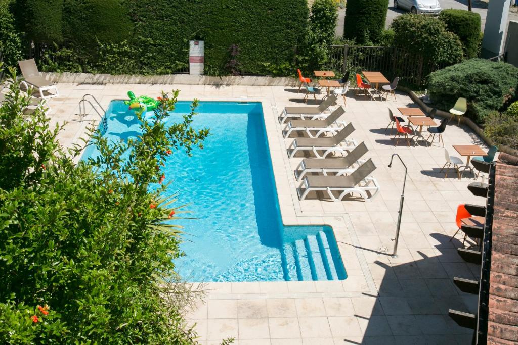 a swimming pool with lounge chairs and a bunch ofituresitures at ibis Avignon Sud in Avignon