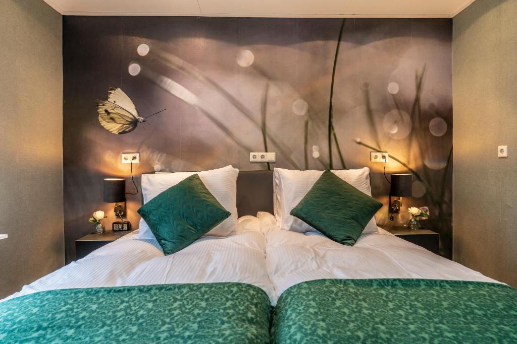 a bedroom with two beds with a butterfly on the wall at B&B Poort van Westerwolde privé appartement met terras op zuiden in Alteveer