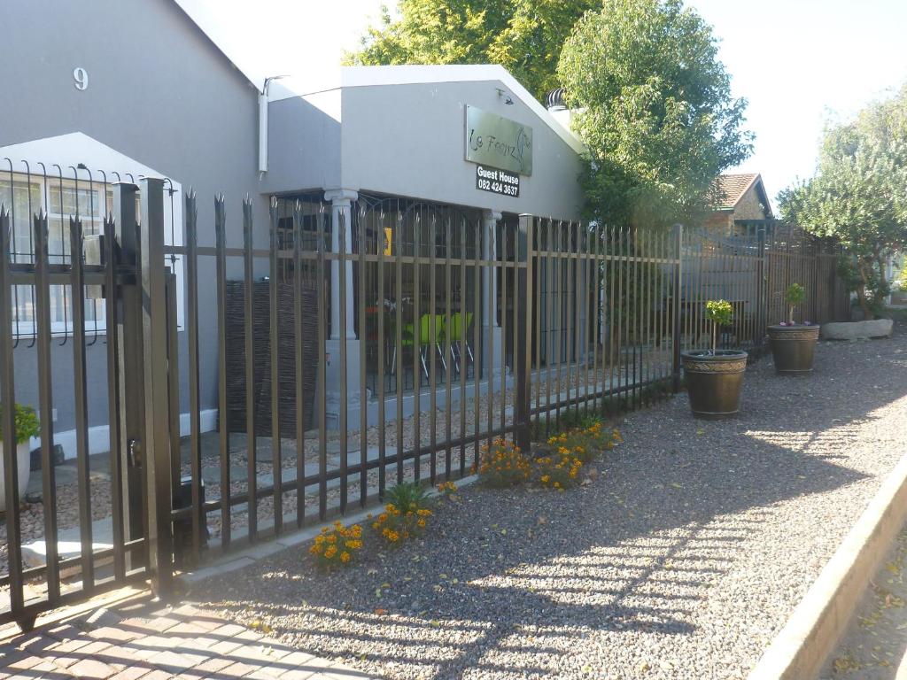 a fence in front of a building with flowers at Le Franz in Parys