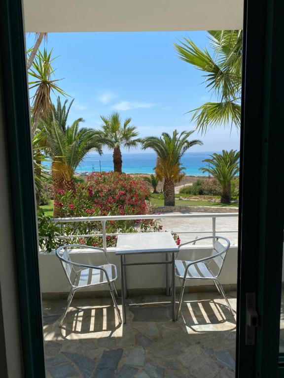 a table and chairs on a balcony with a view of the ocean at Hotel Plakures in Falasarna