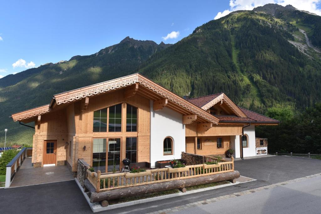 a building with a mountain in the background at Krölls Alpenchalet in Krimml