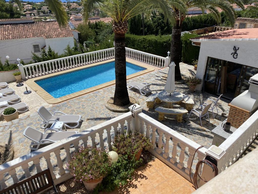 einen Balkon mit einem Pool und Palmen in der Unterkunft Villa Emilia 8 PAX in Calpe