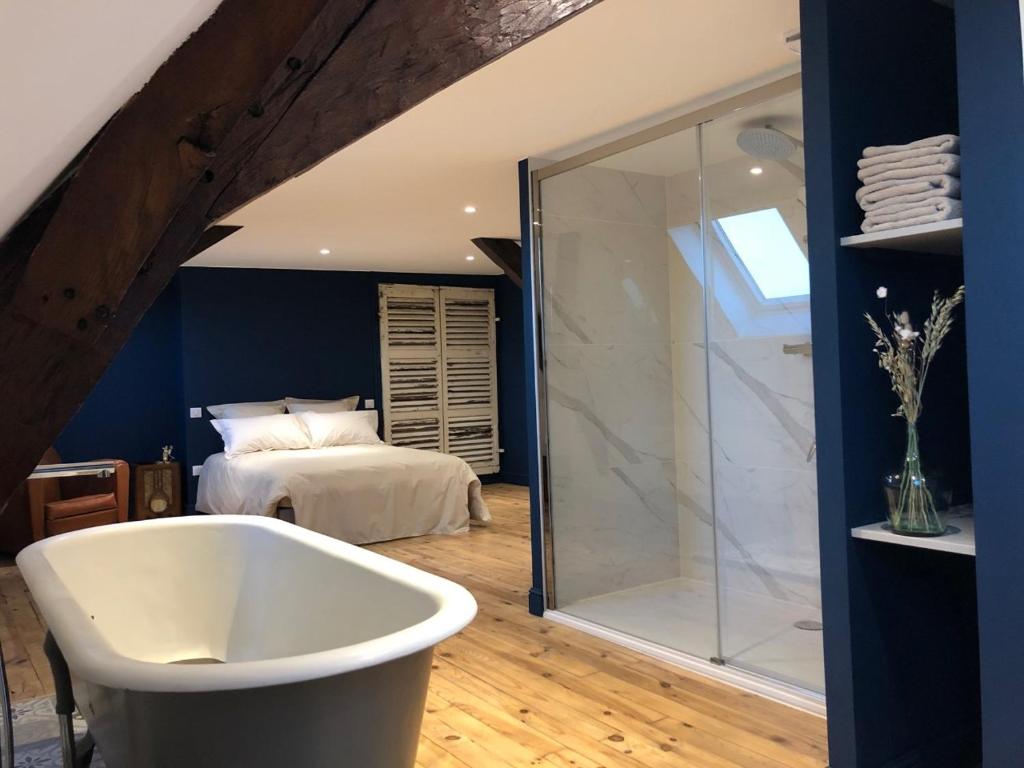 een badkamer met een bad en een slaapkamer bij Les chambres Berguoises Superbe Chambre au coeur de Bergues in Bergues