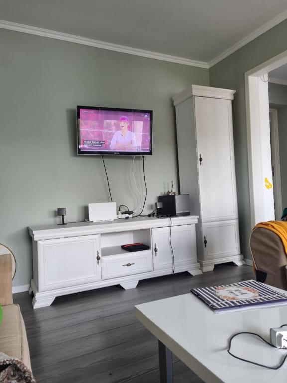 een woonkamer met een wit entertainmentcentrum met een flatscreen-tv bij Aki City Center Apartment in Constanţa