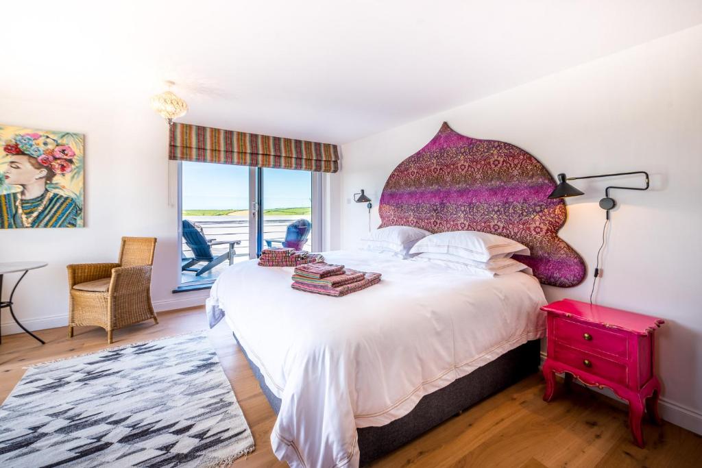 a bedroom with a large bed with a large headboard at Mandalay in Bude