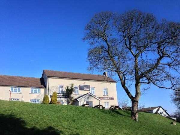 a house on a hill with a tree in front of it at Brewers Lodge in Blackwood