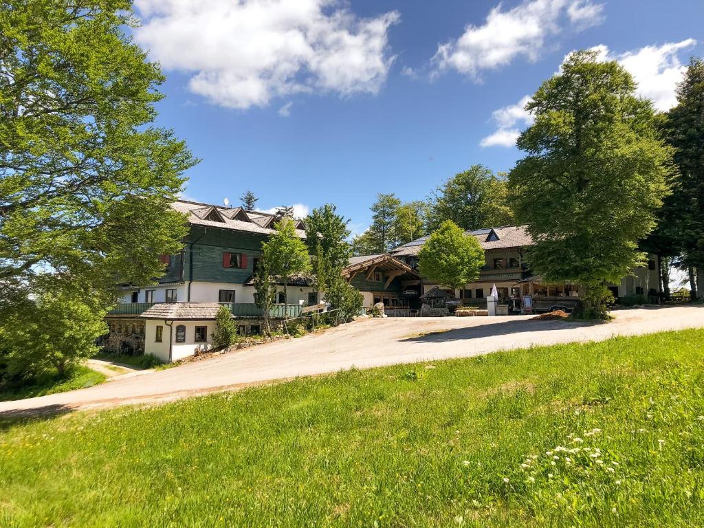 ein großes Haus auf einer Straße mit einem Grasfeld in der Unterkunft Hochberghaus Resort in Grünau im Almtal