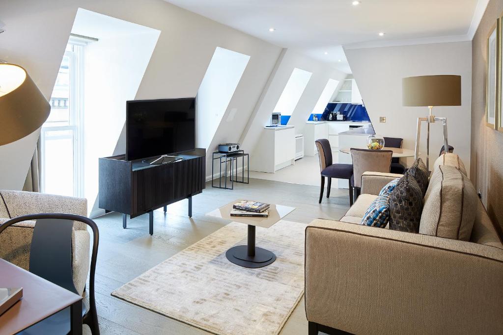 ein Wohnzimmer mit einem Sofa und einem TV in der Unterkunft Cheval Calico House in London