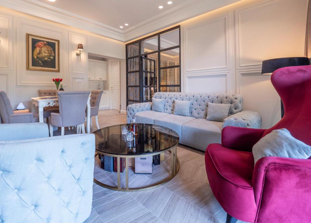 een woonkamer met een bank, stoelen en een tafel bij Apartments PERLA Budva in Budva