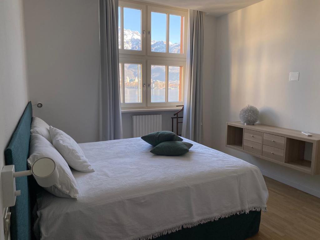 una camera da letto con un grande letto con due cuscini sopra di Little Marina Apartment a Malgrate