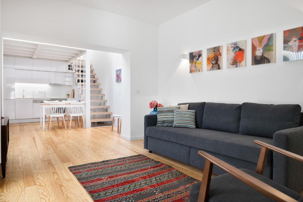 ein Wohnzimmer mit einem blauen Sofa und einer Küche in der Unterkunft Oporto Classic Terrace in Porto
