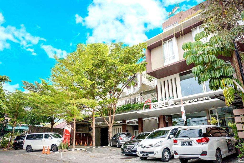 een gebouw waar auto's voor geparkeerd staan bij Andelir Hotel Simpang Lima Semarang in Semarang