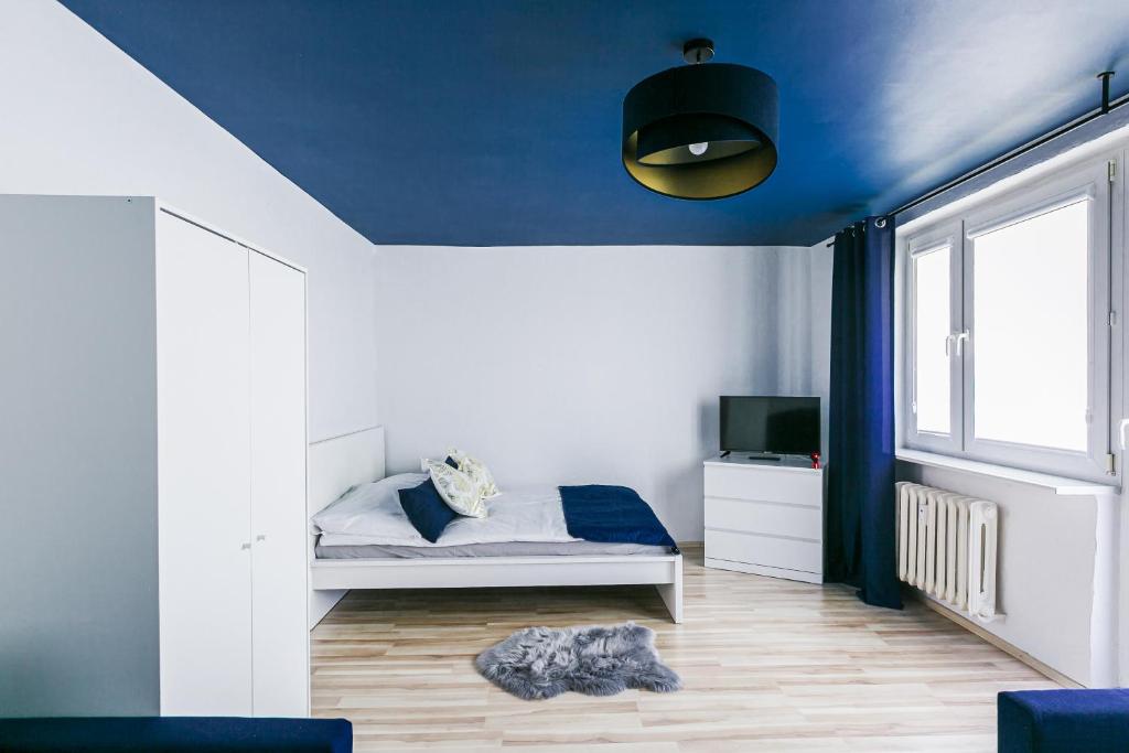 sypialnia z łóżkiem i niebieskim sufitem w obiekcie Apartament w Centrum III w Ustce