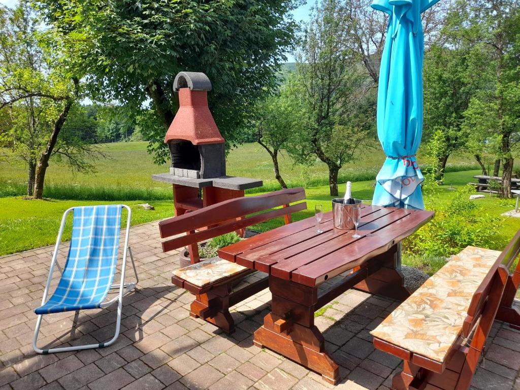 mesa de picnic de madera con estufa y silla en Hiša Pepi, en Ajdovščina