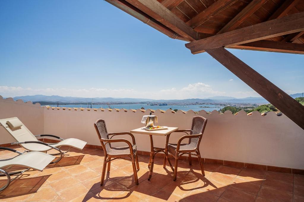 a room with a table and chairs on a balcony at Hotel dP Olbia - Sardinia in Olbia