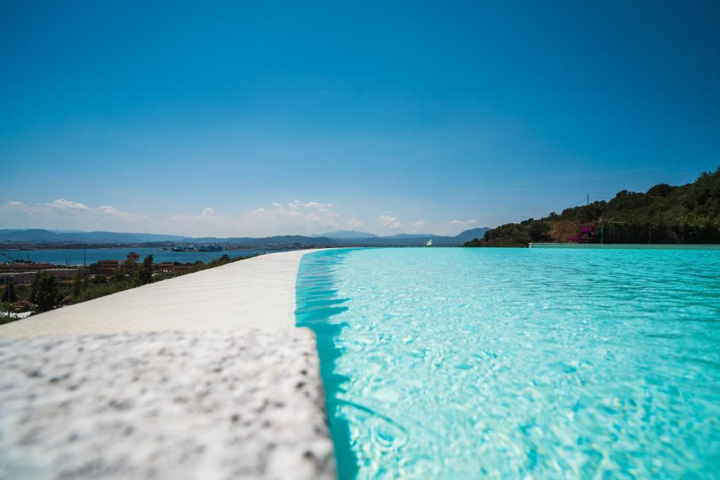 a swimming pool with a view of the water at Hotel dP Olbia - Sardinia in Olbia
