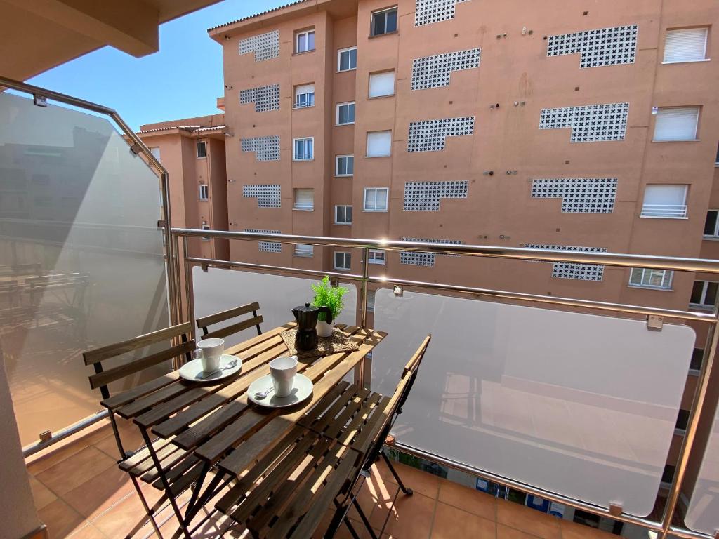 un balcón con mesa y sillas y un edificio en Apartamentos AR Isern, en Blanes