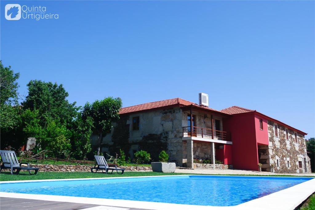 a house with a swimming pool in front of a building at Quinta da Urtigueira in Felgueiras