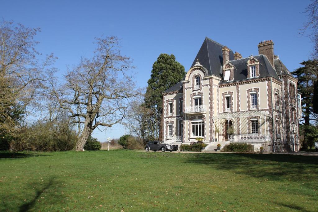 uma antiga mansão com um grande jardim relvado em Château de la Folie em Trie-Château
