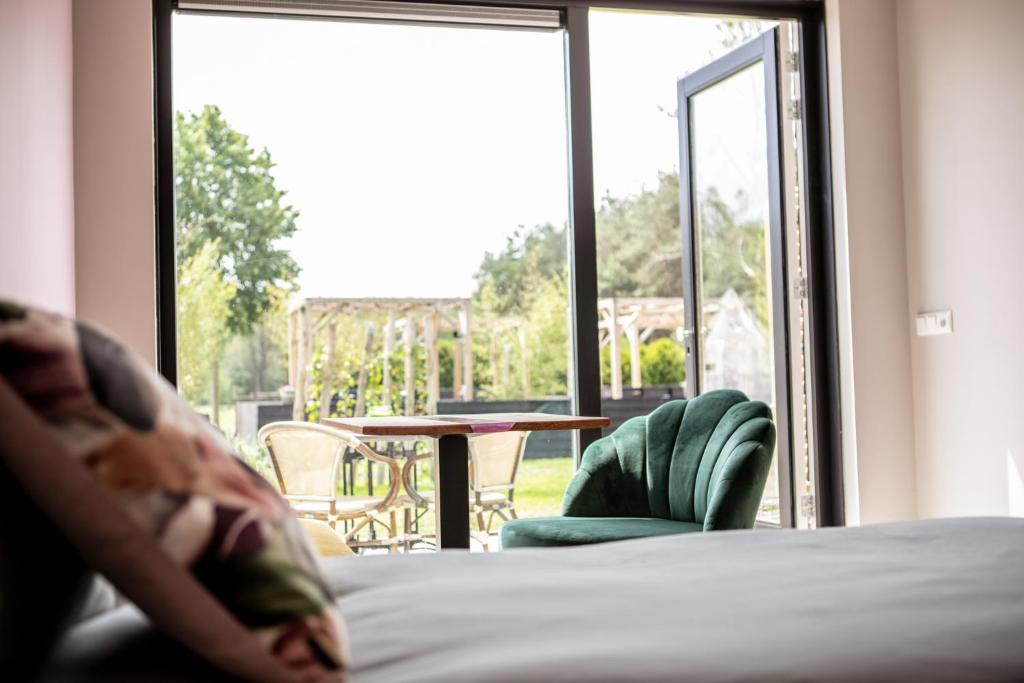 Schlafzimmer mit einem Bett und Blick auf einen Innenhof in der Unterkunft Natuur lodge in Blesdijke