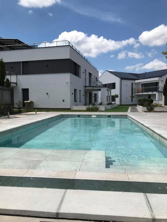 una piscina frente a un edificio en Oasis Residence, en Hajdúszoboszló