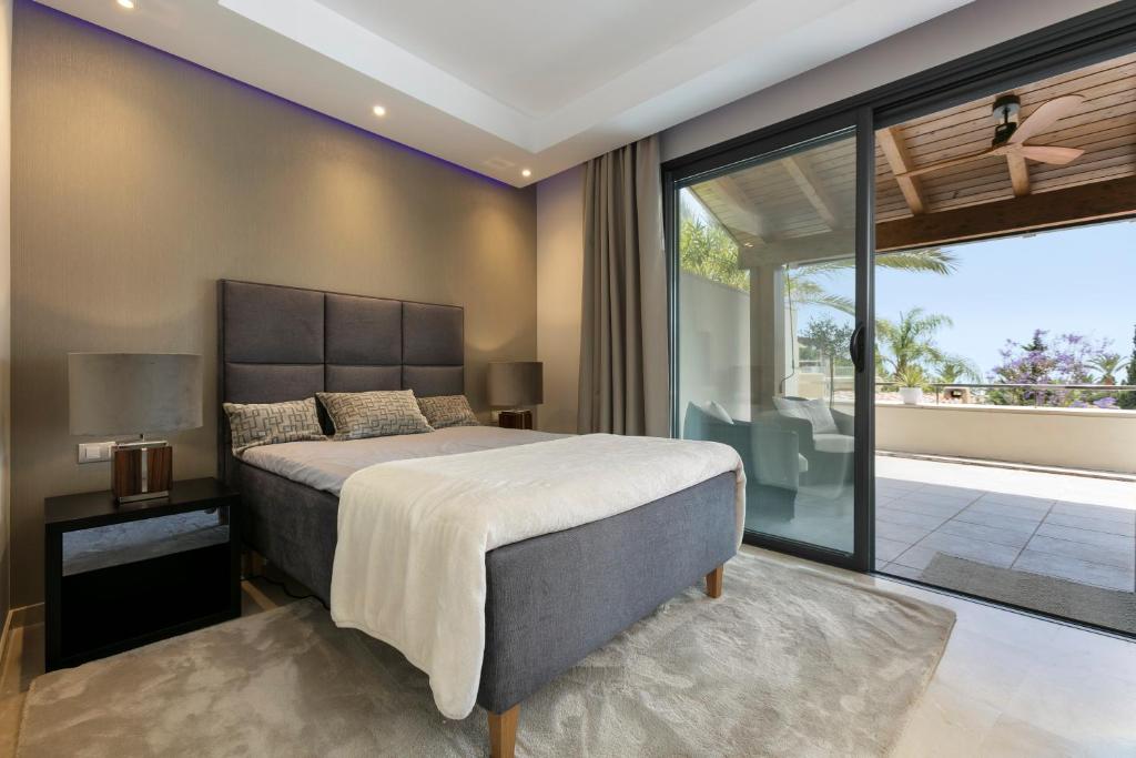 een slaapkamer met een groot bed en een groot raam bij Luxorious duplex Marbella in Marbella