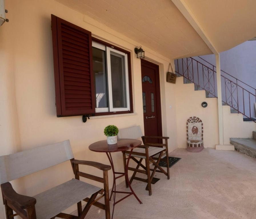 a patio with a table and chairs and a staircase at Manto Apartments Lefkada in Évyiros