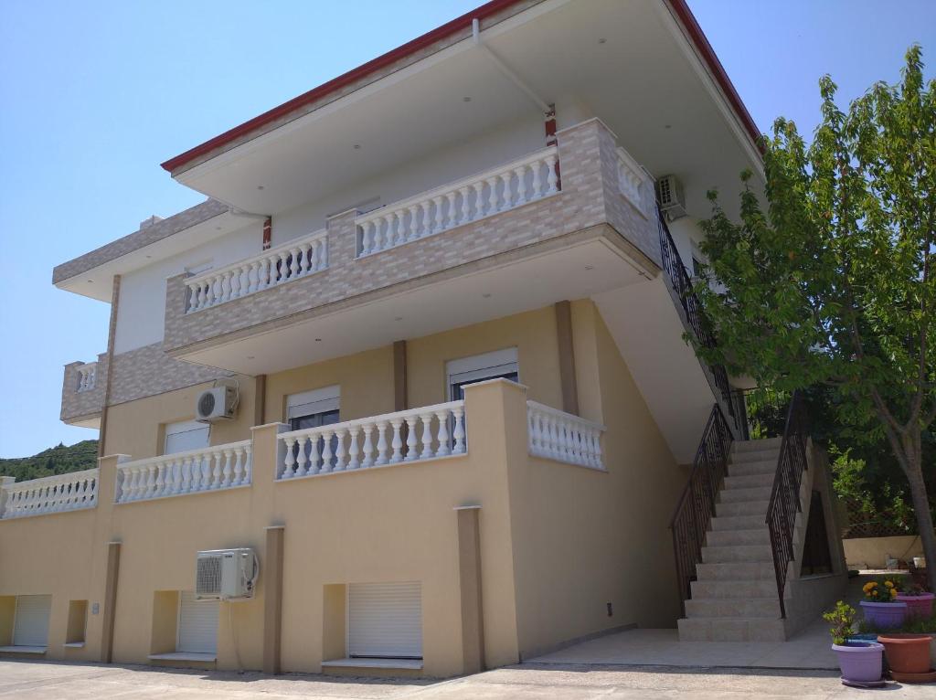 un grand bâtiment jaune avec des escaliers. dans l'établissement Apartments Vladimir, à Ágios Nikólaos