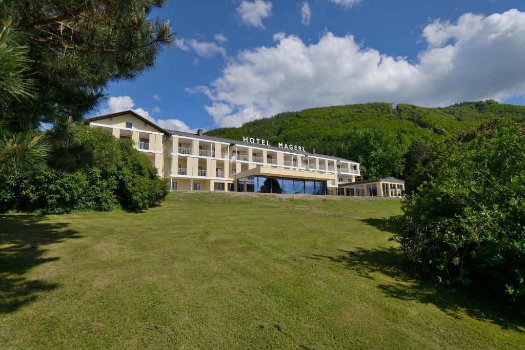 a hotel with a grassy field in front of a building at Hotel Magerl in Gmunden