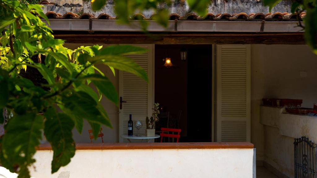una casa con una sedia rossa su un portico di Castellabate Apartments Casa Ronna Rosa a Santa Maria di Castellabate