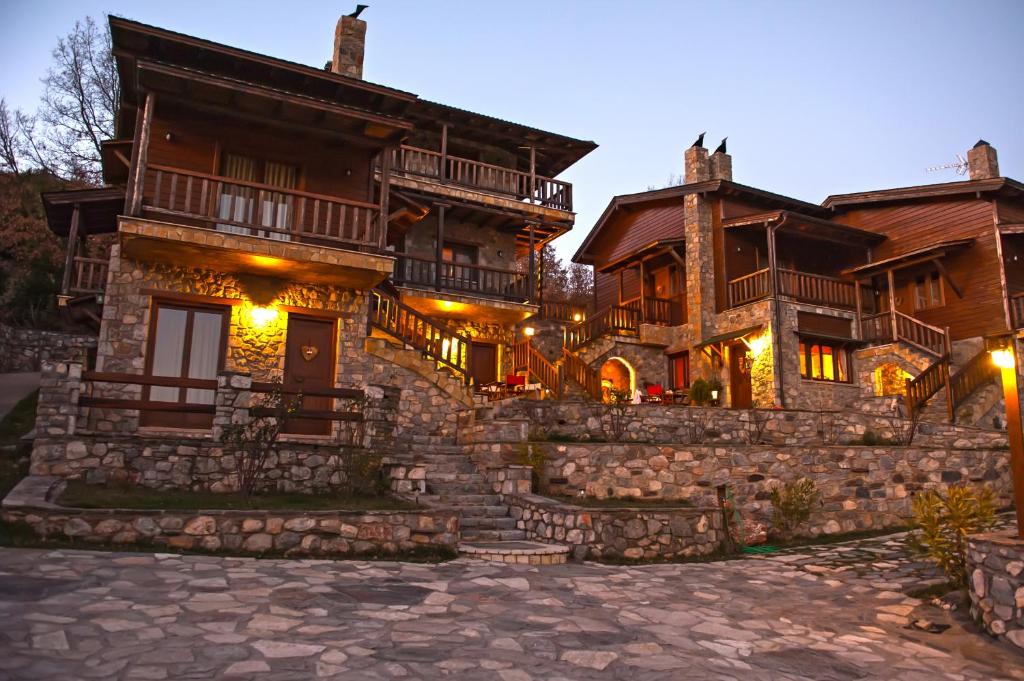 a large wooden house with a stone wall at Efharis Filoxenon in Feneos