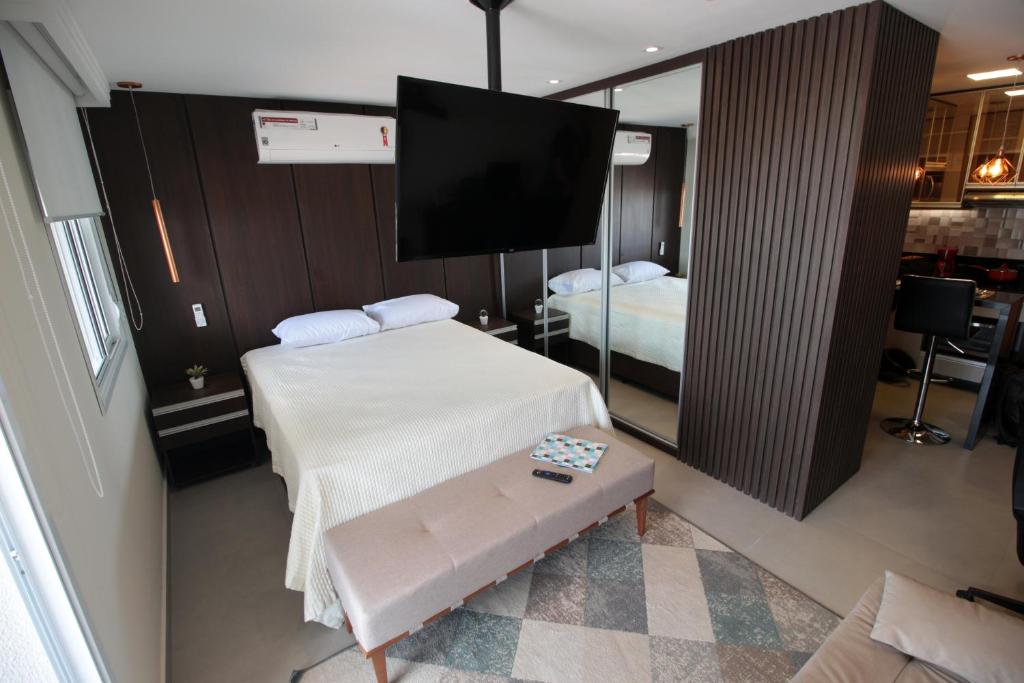 Camera con letto e TV di Flat 2211 - Guarulhos Aeroporto - Wi-fi - Estacionamento - Home Office - Shoppings a Guarulhos