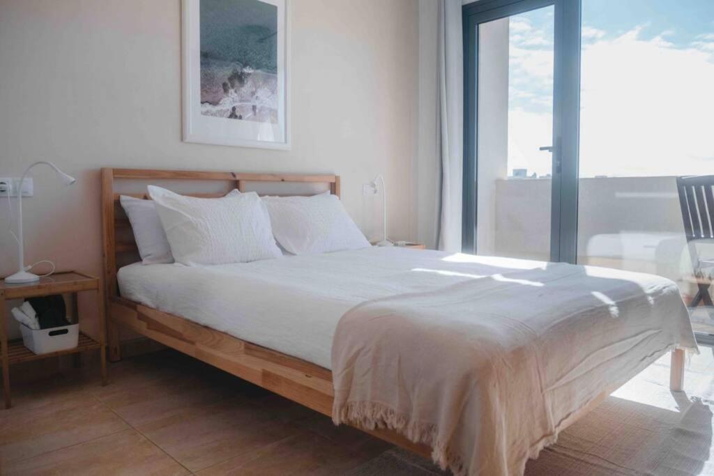 a bedroom with a large bed with white sheets at Wave & Chill -The House- in Cotillo