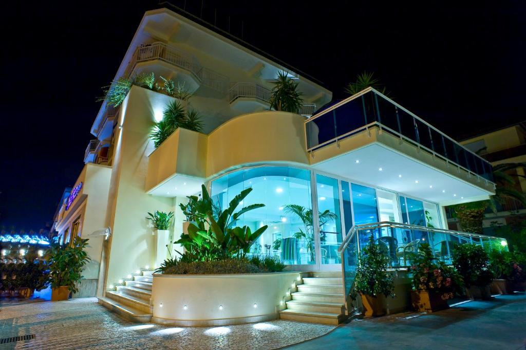 a large building with stairs and plants in front of it at Hotel Prater in Grottammare